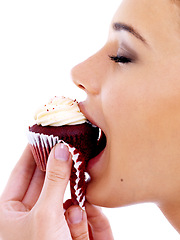 Image showing Studio, woman and eating cupcake with happiness for nutrition, satisfaction and unhealthy snack. Female person, food and sweet dessert with red velvet, enjoyment and tasty muffin on white background