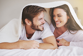 Image showing Happy, love and couple in conversation with blanket for relaxing, bonding and resting on bed together. Happy, romantic and young man and woman laying with duvet in bedroom at hotel, home or apartment