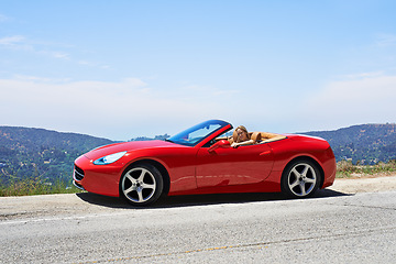 Image showing Woman, red convertible and road trip on mountain, travel and luxury transport on summer drive. Happy female person, holiday and countryside wellness on street, vacation and adventure in vehicle