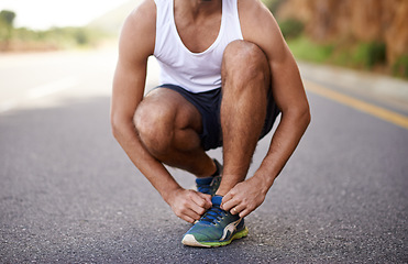 Image showing Man, feet and tying laces on road for running, prepare and shoes for cardio or training for marathon. Male person, legs and fitness on mountain street for performance, athlete and ready for exercise