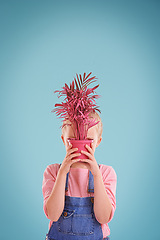 Image showing Child, face and pot plant in studio or hiding with blue background for mockup space, colorful or decoration. Female person, kid and youth in Australia for growth development, floral or eco friendly