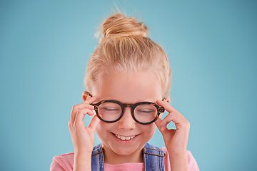 Image showing Child, glasses and optometry vision in studio or healthy eyes on blue background for prescription, lenses or mockup space. Female person, smile and frame spectacles or development, growth or wellness