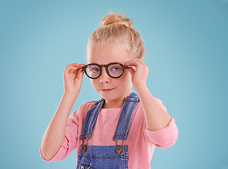 Image showing Child, portrait and eye glasses optometry in studio or healthcare vision for youth development, blue background or mockup space. Female person, kid and eyewear for spectacles frame, sight or lens