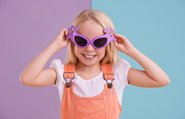 Image showing Girl, child and sunglasses with smile for fashion, groovy style and colour block background. Confidence, young kid and funky face accessory in studio with cool shades, happiness and trendy outfit