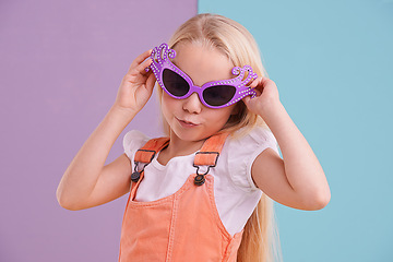 Image showing Sunglasses, pose and girl with fashion for style, groovy clothes and colour block background. Young kid, confidence and pout with groovy accessory for emoji, happiness and trendy outfit in studio