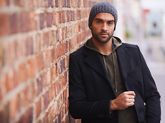 Image showing Man, portrait and urban style by brick wall downtown for aesthetic, modern and vacation for city culture. Male person, trendy winter outfit for streetwear fashion for creative career in New York