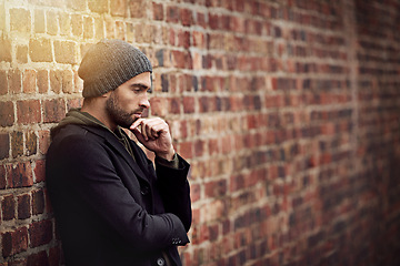 Image showing Fashion, man and thinking in brick wall outdoor with trendy, cool and style for urban with idea. Male person, choice and planning for weekend or holiday with winter outfit and stylish in Germany