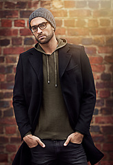 Image showing Man, portrait and winter fashion by brick wall downtown for aesthetic, modern and expression for city culture. Male person, trendy urban outfit for streetwear style for creative career in retail