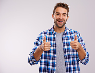 Image showing Portrait, excited and man with thumbs up for success, winning or feedback isolated on a gray studio background mockup space. Face, happy person and like hand gesture for emoji, agreement or thank you