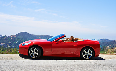 Image showing Woman, red convertible and road trip on mountain, travel and luxury transport on summer drive. Happy female person, holiday and countryside wellness on street, vacation and adventure in vehicle