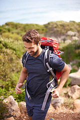 Image showing Man, hike and mountain for recreation with rocks and trees for nature and outdoor in environment. Young person, smile and bag for fitness and active for walk and adventure for exercise and sport