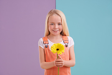 Image showing Fashion, flower and portrait of child in studio with cute, trendy and casual dress for outfit. Sweet, smile and young girl kid with style and yellow floral plant for gift by color block background.