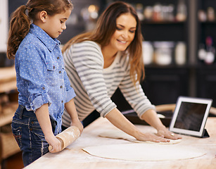 Image showing Pizza, dough and child with mother in kitchen and tablet for recipe, guide and learning from online tutorial. Cooking, together and girl help with rolling pin and baking with mom in home for dinner