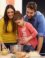 Image showing Parents, girl and kitchen for baking with love, ingredients for cake or dessert with support and handmade with care. Mom, dad and kid together in family home for bonding or teaching with affection.