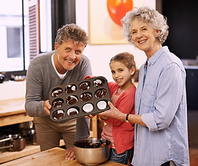 Image showing Girl, grandparents and portrait with cupcakes, kitchen and baking together. Mature couple, smile and child for happiness, love and learning at home with grandmother for childhood memories and family
