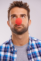 Image showing Clown, nose and man thinking with funny, crazy and comedy with idea in a studio. Costume, quirky and looking up with a male person with grey background and comedian ready for a joke with red prop