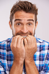 Image showing Nervous, portrait and man with nail bite for anxiety, fear and funny stress gesture in a studio. Worried, scared and male person with hands to face for comedy with grey background and modern style