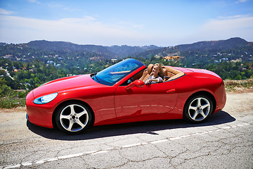 Image showing Convertible, car and woman on a drive in city, outdoor in summer with happiness on road trip. Luxury, transport and portrait of female driver to travel on highway hill with red vehicle on street