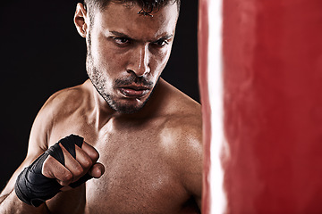 Image showing Boxing, man or serious in studio with punching bag for training, exercise or competition fight with fitness. Athlete, boxer or workout for martial arts with performance or topless on black background