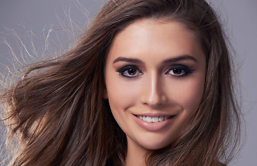 Image showing Haircare, portrait and happy woman in studio for salon, shampoo treatment and glow on isolated grey background. Closeup, smile and face of female model with natural cosmetics, hairstyle and volume