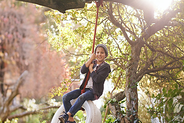 Image showing Boy, tyre swing and portrait in garden with happiness, playing and countryside vacation in summer. Child, face and diy adventure playground in backyard of home with sunlight, trees or smile in nature