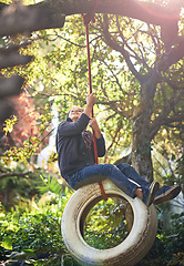 Image showing Boy, tyre swing and playing in garden with happiness, recreation or countryside vacation in summer. Child, excited and diy adventure playground in backyard of home with sunlight and trees in nature