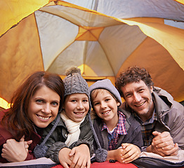 Image showing Portrait, smile and family camping in tent on vacation, holiday or travel together. Face, parents and happy children at campsite with kids bonding to relax with mother and father on adventure trip