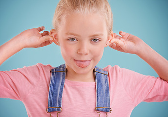 Image showing Child, portrait and funny face in studio for humor on blue background with silly mood, mockup space or happiness. Female person, girl and tongue out in Australia with goofy, confidence or positivity