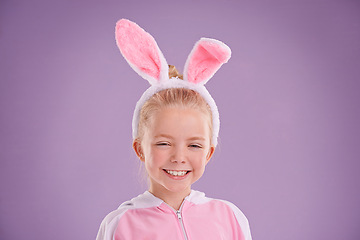 Image showing Child, bunny and portrait with smile, studio and celebration for easter holiday. Girl, costume and youth with pastel, rabbit and happy for fun cute childhood dress up isolated on purple background