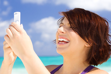 Image showing happy woman with phone on the beach