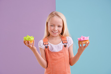 Image showing Child, cupcake and portrait for colorblock in studio for dessert, pastry and icing for sugar, cake and frosting. Little girl or kid and smile for decide with green or pink for happy and delicious