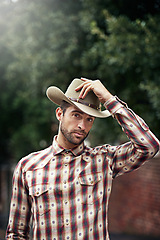 Image showing Man, portrait and outdoor cowboy style, western culture and countryside ranch in Texas. Male person, hat and flannel fashion for farmer aesthetic, nature and plaid trend by trees or outside bush