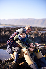 Image showing Father, fishing and portrait of young boy, seaside and bonding for activity by ocean. Sea, rod and learning how to fish for childhood development, winter and hobby together while on ocean vacation