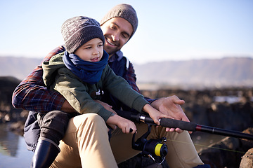 Image showing Father, kid and fishing at sea in winter as hobby with bonding for child development, growth and life skills in Australia. Dad, boy and sit at rock in coast for family tradition, memory and care