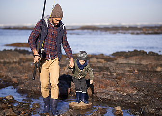 Image showing Man, kid and fishing at sea in winter as hobby with bonding for child development, growth and life skills in Australia. Dad, boy and stand in boulders at coast for family tradition, memory and care