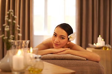 Image showing Spa, bed and portrait of woman with candle for aromatherapy, stress relief or holistic body massage. Asian person, zen face and smile at luxury hotel for hospitality, self care and natural wellness