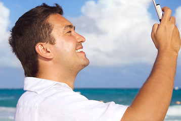 Image showing happy man with phone on the beach