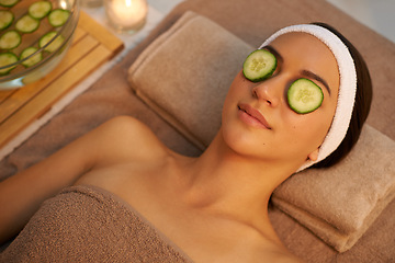 Image showing Top view, skincare and woman with cucumber on eyes at massage table in spa for peace, relax or wellness. Mask, above and person with vegetable on face for natural beauty or healthy organic treatment