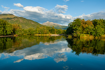 Image showing Majestic mountains reflecting in serene lake on a sunny afternoo