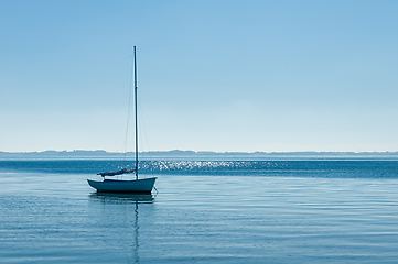 Image showing Serene sailboat on tranquil waters under clear blue skies at dus