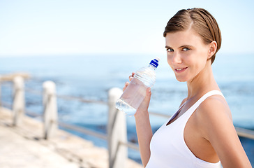 Image showing Woman, water bottle and outdoor at beach for health, fresh air and fitness in nature, h2o and sea. Nutrition, detox and liquid for thirst, hydration and exercise in portrait with drink for wellness