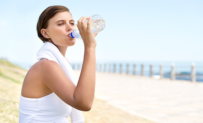 Image showing Woman, drink water and outdoor at beach for health, fresh air and fitness in nature, h2o and sea. Nutrition, detox and mineral liquid for thirst, hydration and exercise with beverage for wellness