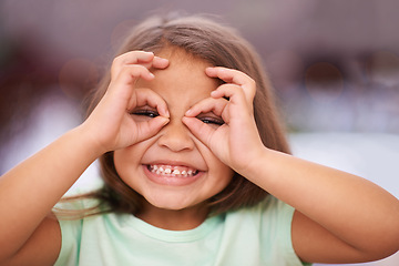 Image showing Portrait, girl and child with hands on eyes for playful or silly facial expression, funny and happiness. Female kid, adorable with gesture on face for vision or glasses, youth and childhood with fun.