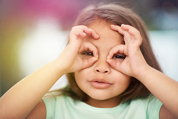 Image showing Portrait, child and circle with hands on eyes for playful or silly facial expression, funny and happiness. Girl kid, adorable with gesture on face for vision or glasses, youth and childhood with fun.