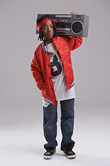 Image showing African boy, hip hop and fashion portrait with radio for rap music and dance in a studio with urban clothing. Black kid and boombox with trendy clothes and swag with confidence and grey background