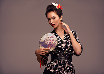 Image showing Asian woman, fashion and confident with hand mirror in studio on brown background in traditional style and elegant. Portrait, Japanese and female person with designer clothes or outfit for heritage