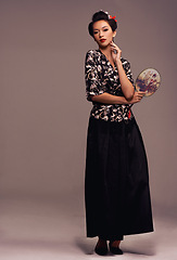 Image showing Portrait, Asian woman and fashion with with hand mirror in confidence on studio on brown background in traditional style and elegant. Japanese, female person and designer clothes with outfit.