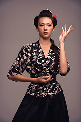 Image showing Fashion, art portrait and Japanese woman with confidence and Asian clothing with traditional outfit in studio. Culture, creative and heritage clothes with person from Japan and brown background