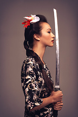 Image showing Japanese woman, fashion and sword with confidence in studio on brown background in traditional style and elegant. Asian, culture and female person with designer clothes or outfit for heritage