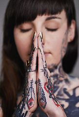 Image showing Woman, tattoo and pray for ink, faith and creative for belief, religion and spiritual for design on closeup. Young person and eyes closed for zen, namaste and nails for varnish and symbol for edgy